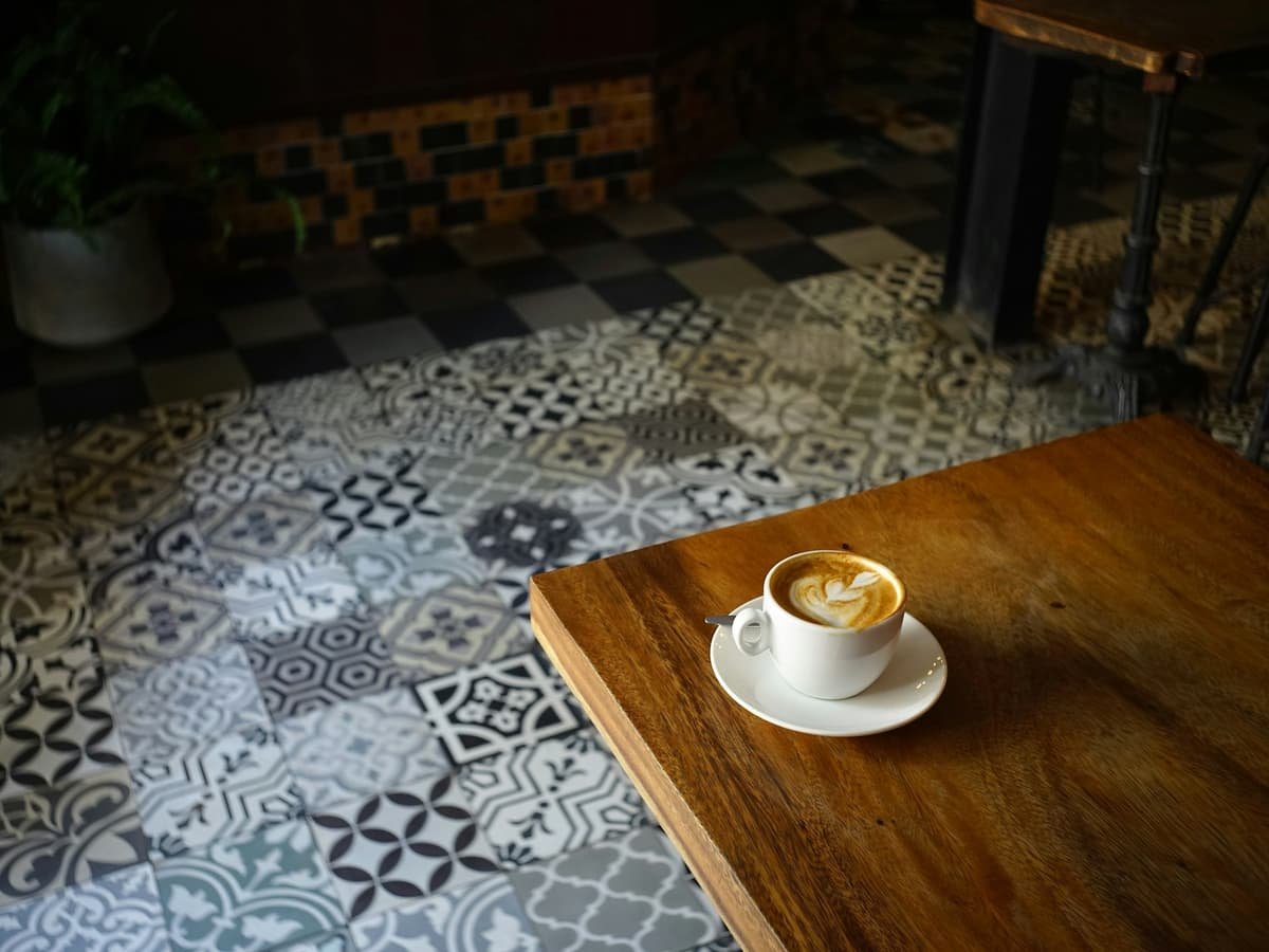A cup of coffee sitting on top of a wooden table