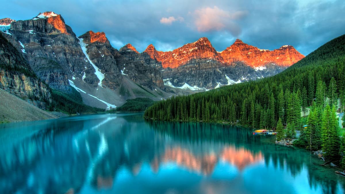 Moraine Lake reflecting snow-capped peaks in the Canadian Rockies at golden hour