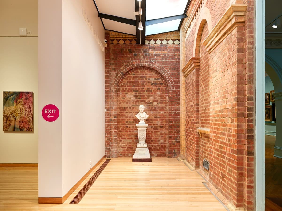A hallway with a statue and a skylight