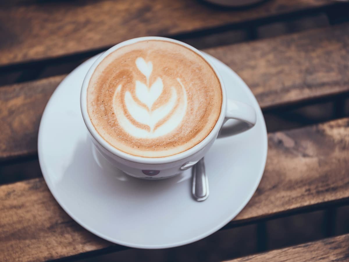 A cappuccino on a saucer on a wooden table