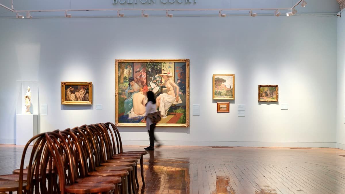 A room filled with wooden chairs and paintings