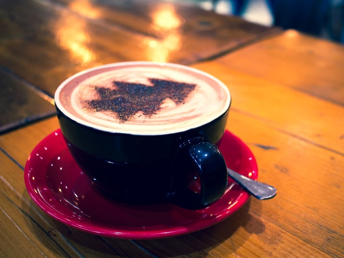 Blue cup with cappuccino on red bowl