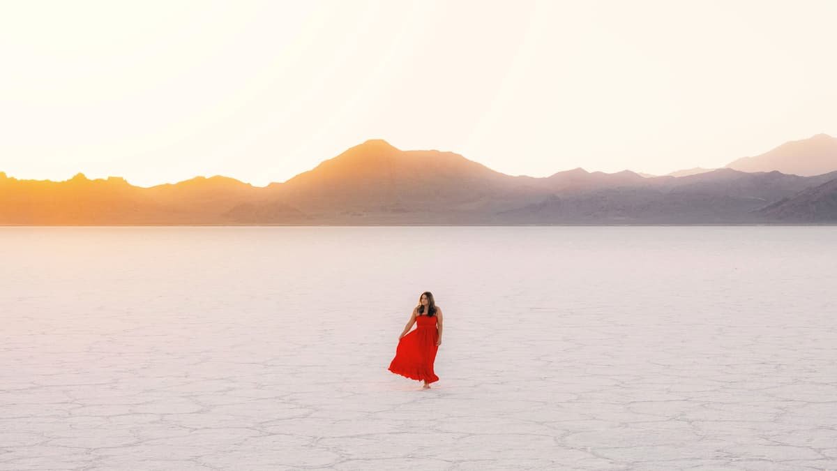 Woman in red dress walks across salt flats, date night in British Columbia