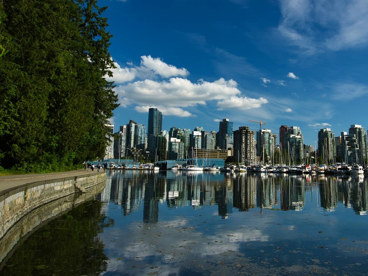 City skyline across body of water under blue and white sunny cloudy sky during daytime: date idea in British Columbia