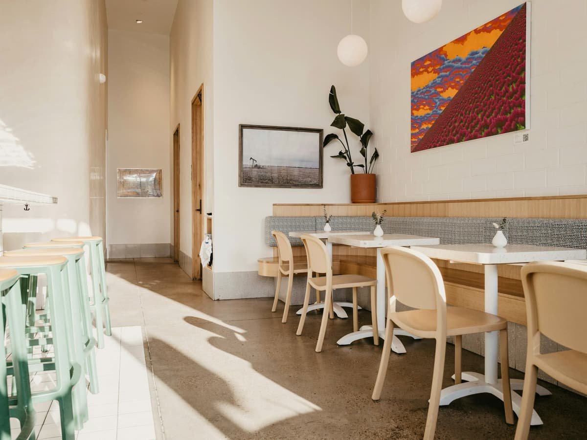 A restaurant with tables and chairs and a painting on the wall: date idea in Manitoba
