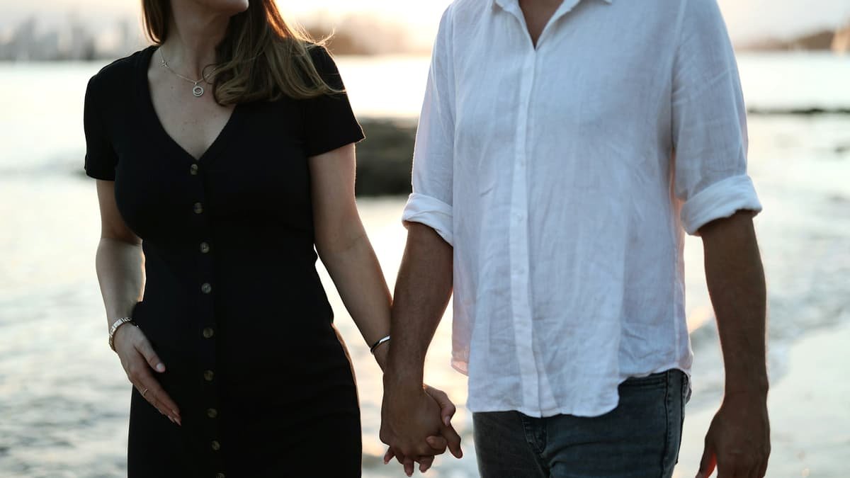 A man and a woman holding hands on the beach, date night in Manitoba
