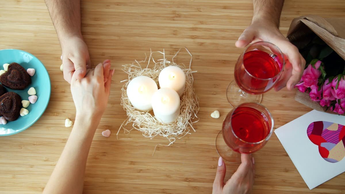 Couple holding hands with wine and chocolates, date night in Manitoba