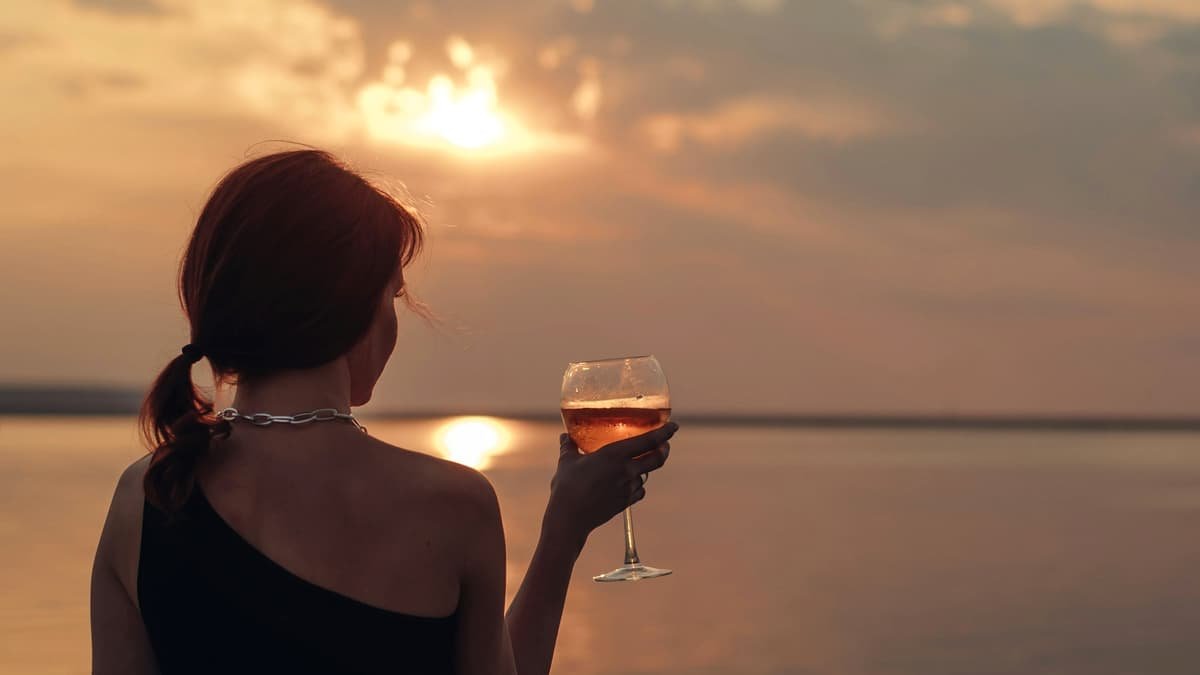 A woman holding a glass of wine at sunset, date night in New Brunswick