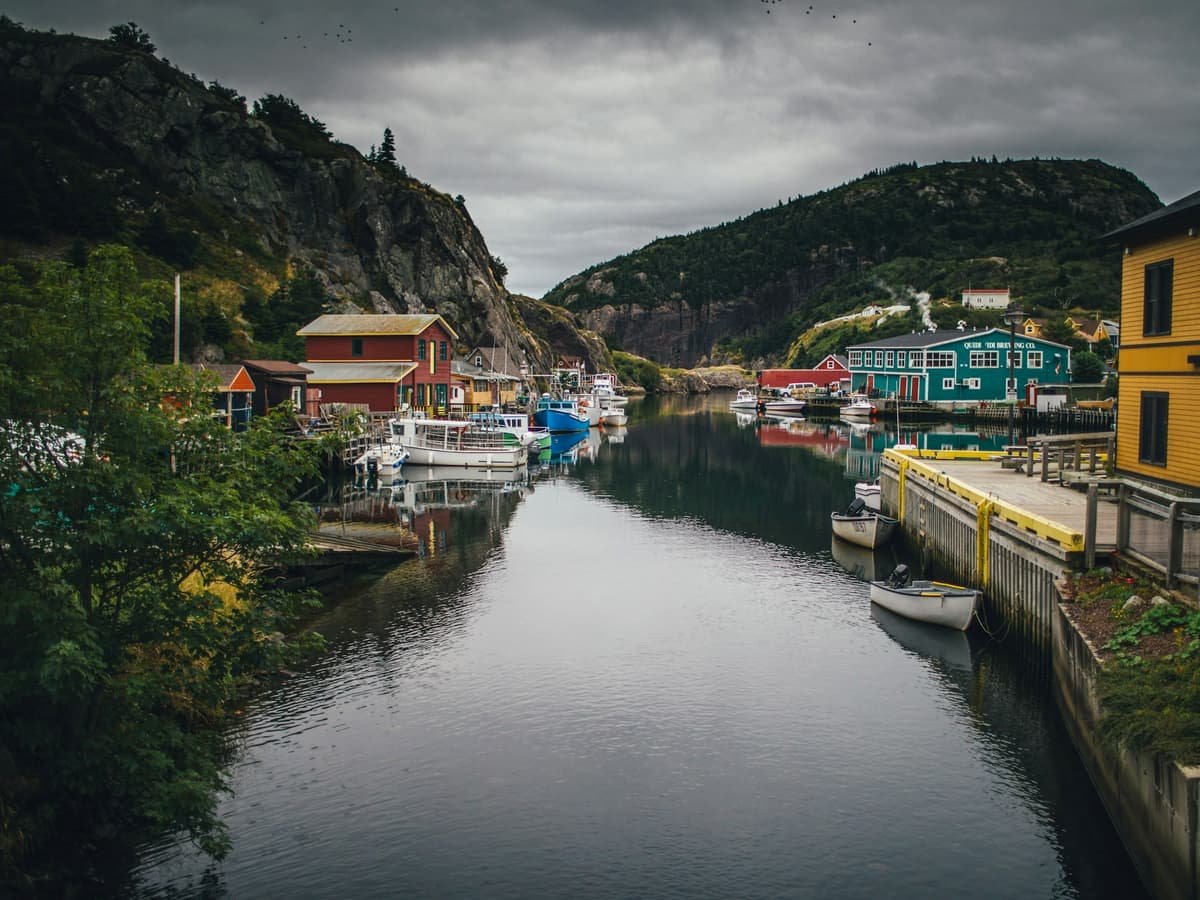 A body of water with boats and buildings along it: date idea in Newfoundland and Labrador
