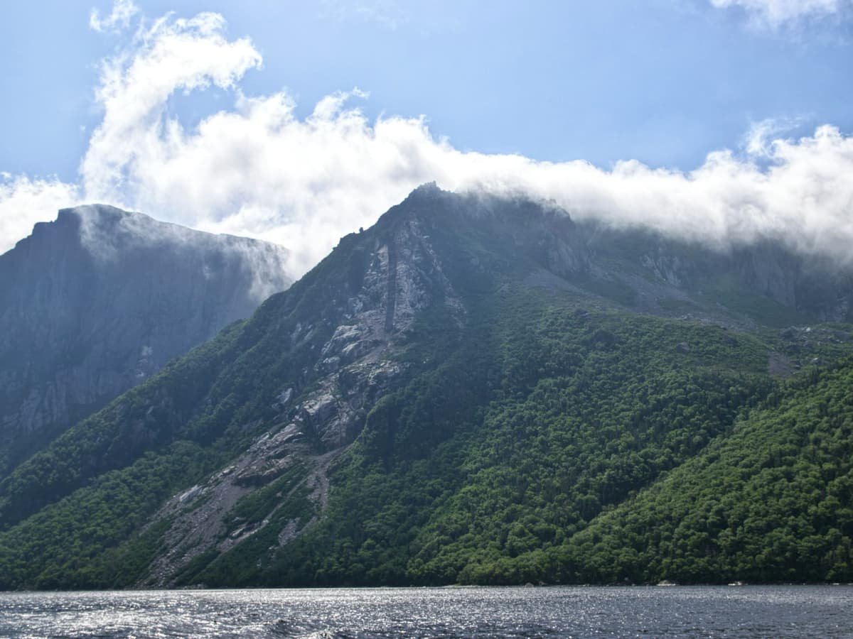 Lake viewing mountain under blue and white skies during daytime: date idea in Newfoundland and Labrador