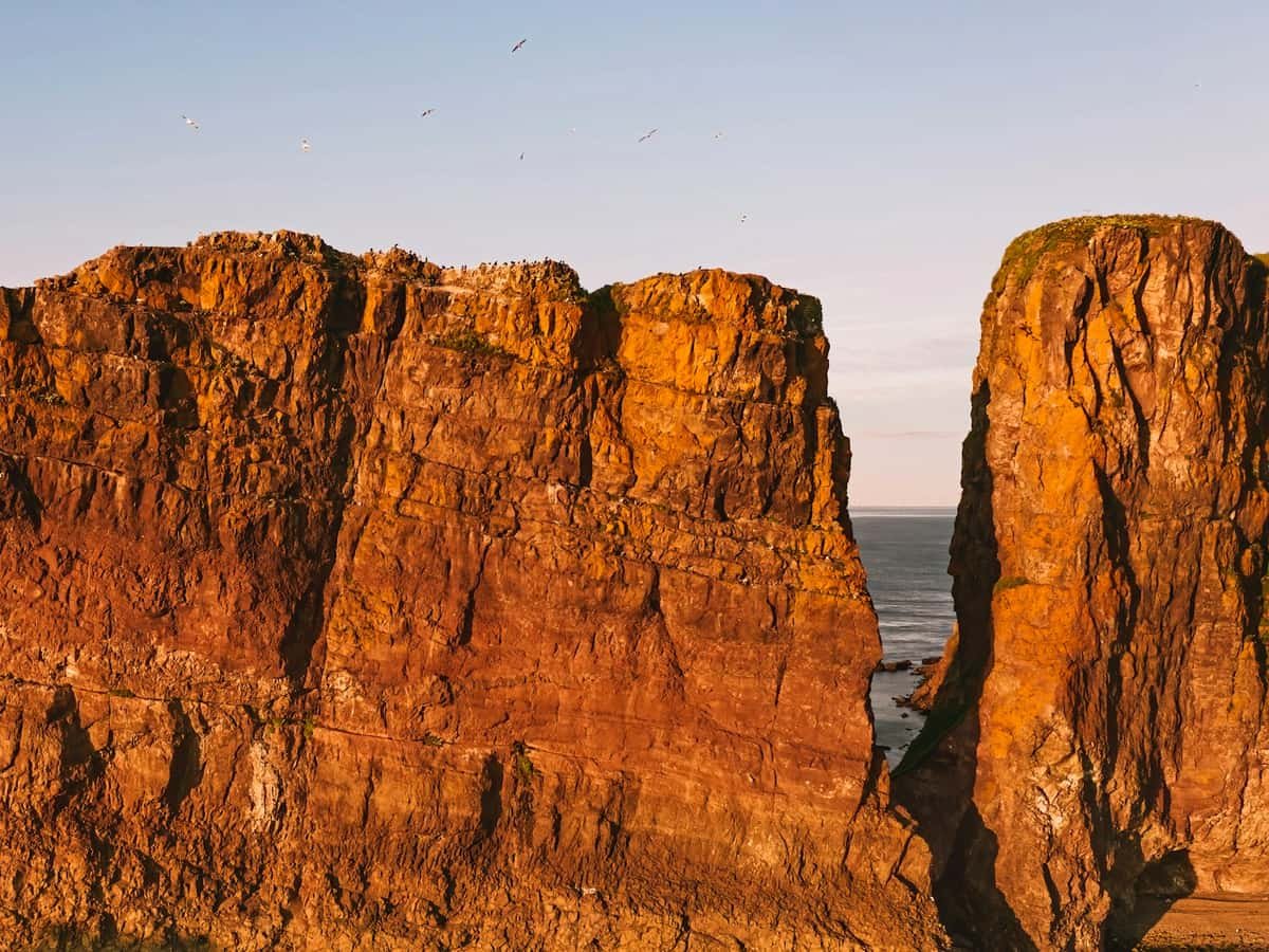 Brown rock formation under blue sky during daytime: date idea in Nova Scotia
