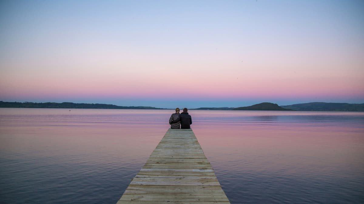 Two persons sitting on ocean dock, date night in Nova Scotia