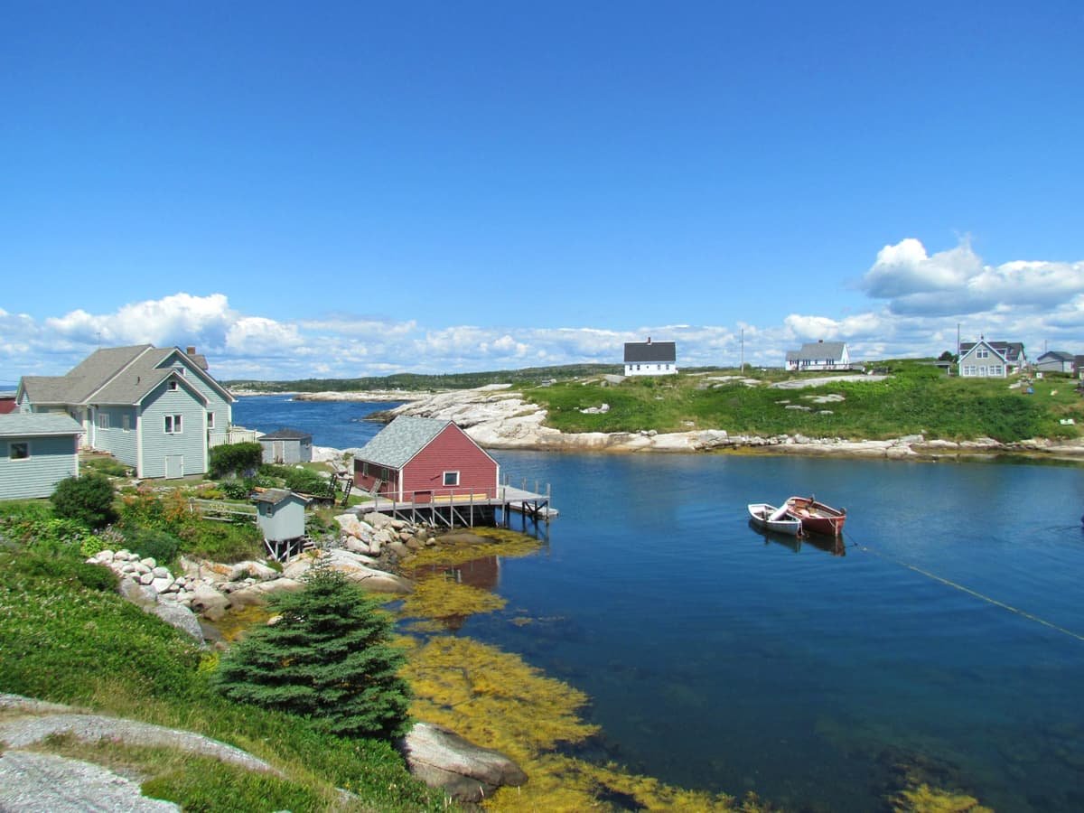 White and brown wooden house beside river under blue sky during daytime: date idea in Nova Scotia
