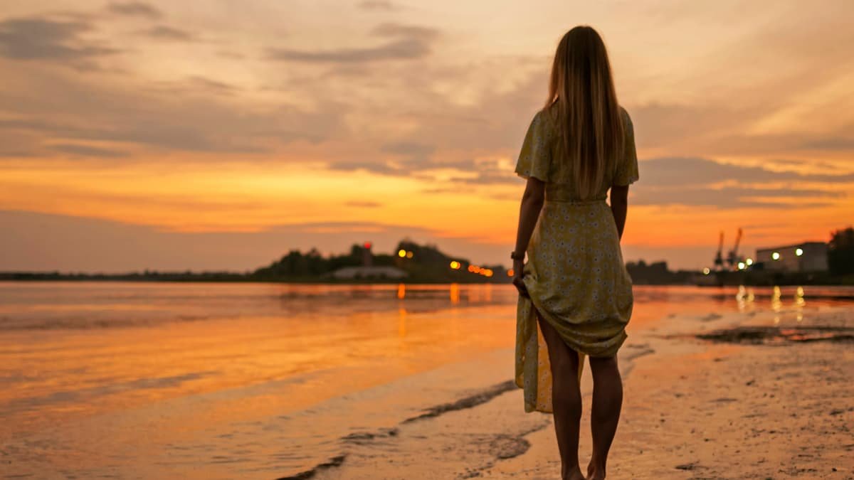 Woman in a summer dress walking on the beach at sunset, date night in Ontario