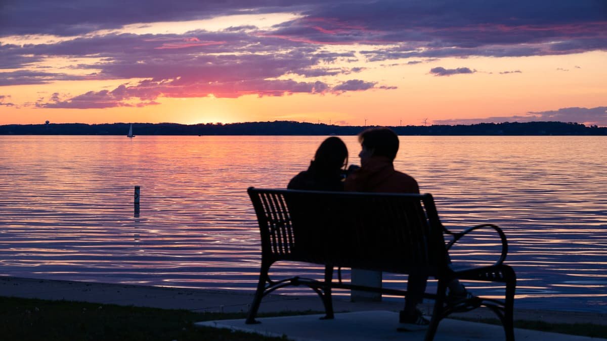 Couple watches the sunset over the water, date night on Prince Edward Island
