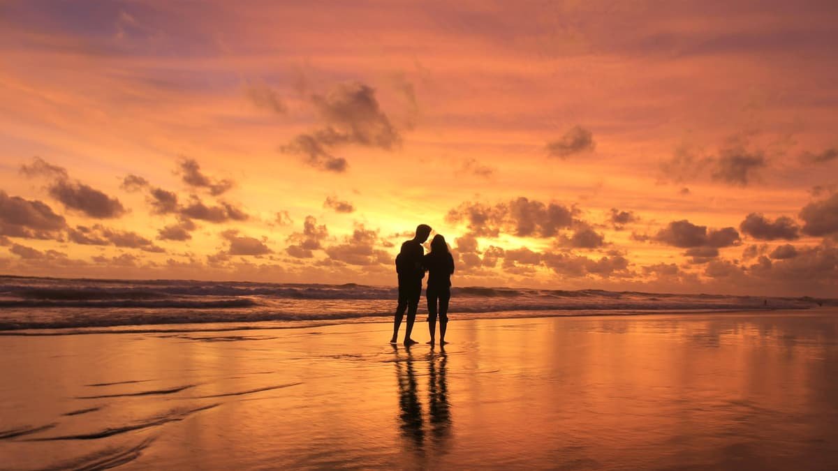 A couple of people standing on top of a beach, date night in Saskatchewan