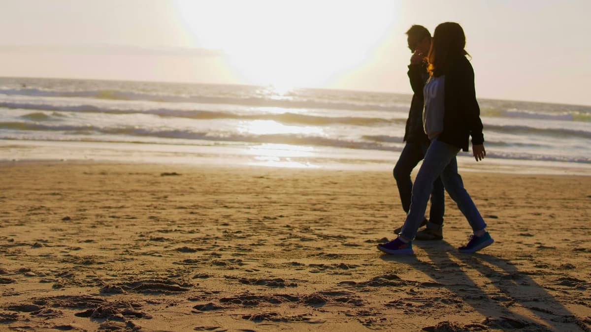 Two people walking on a beach near the ocean, date night in Saskatchewan